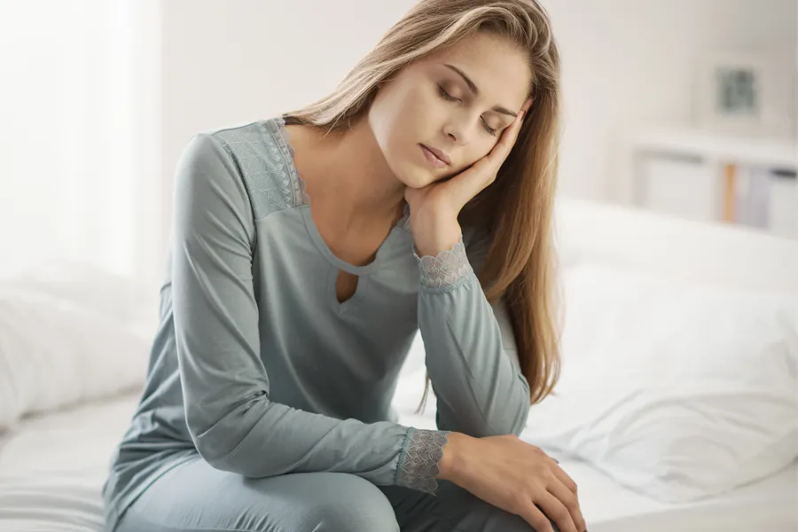 Depression-Clinic A woman sits on the edge of her bed with her head in her hands. Schedule treatment for depression from Sandra McDonald, NP in Southwestern Ontario.