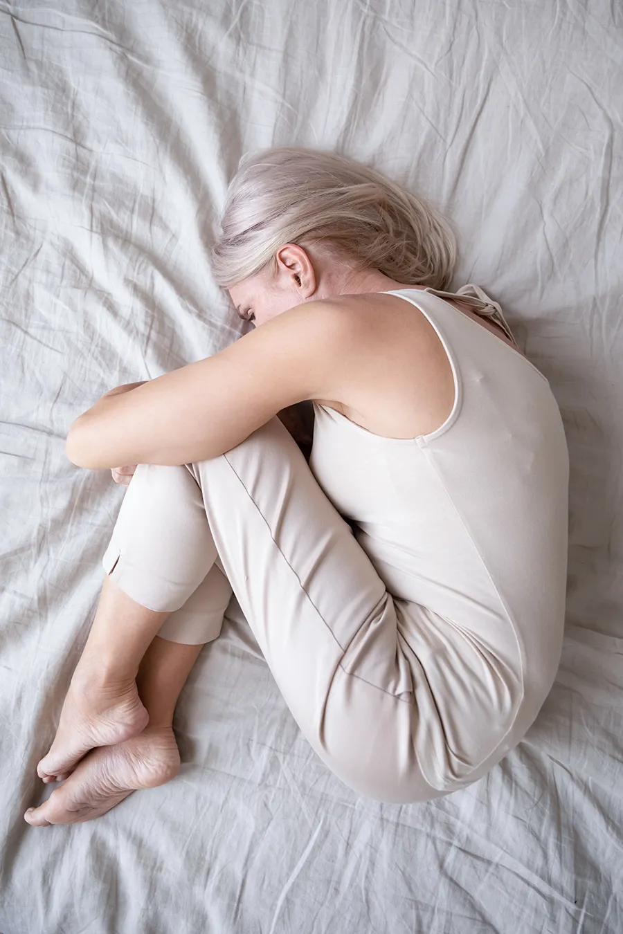 Depression-Treatment A woman curled up in her bed. Get treatment for Depression from Sandra McDonald, NP in Southwestern Ontario.